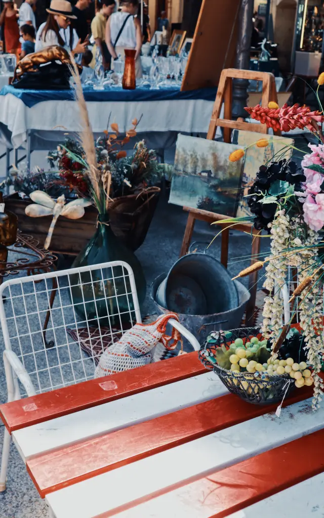 Ensemble d'objets décoratifs, de fleurs séchées, présenté dans un espace de brocante.