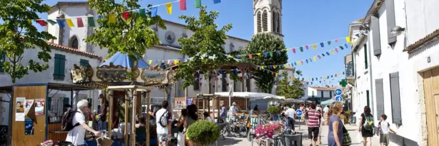 Scène animée d'un marché à La Couarde-sur-Mer avec des vélos et des piétons.