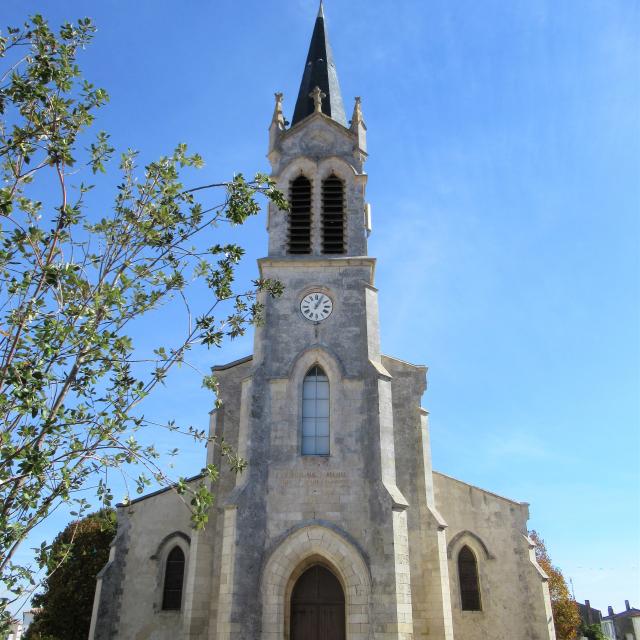 Église Notre-Dame-de-l’Annonciation vue de près avec un jeune arbre à sa gauche