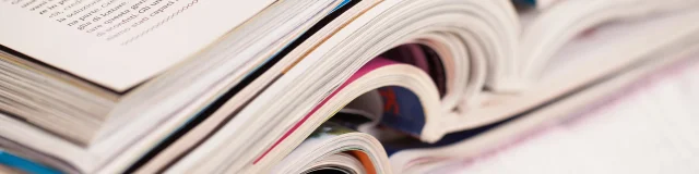 Pile of colorful magazines on a white table
