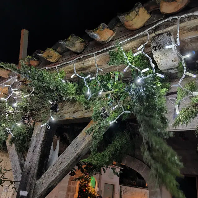 Branche de sapin et guirlande lumineuse suspendues aux halles du marché