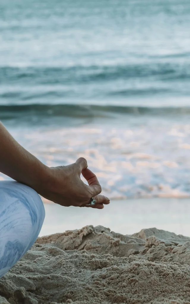 Femme pratiquant le yoga sur la plage.
