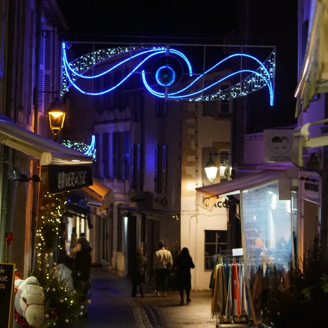 Rue piétonne illuminée avec des décorations de Noël à Saint-Martin-de-Ré.