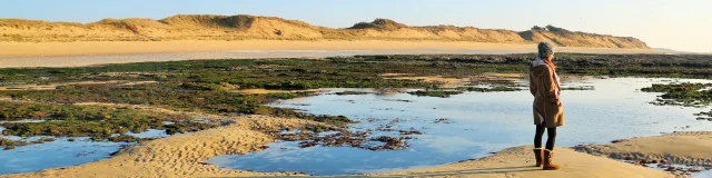Femme marchant sur le sable humide au bord de la mer sur l'île de Ré
