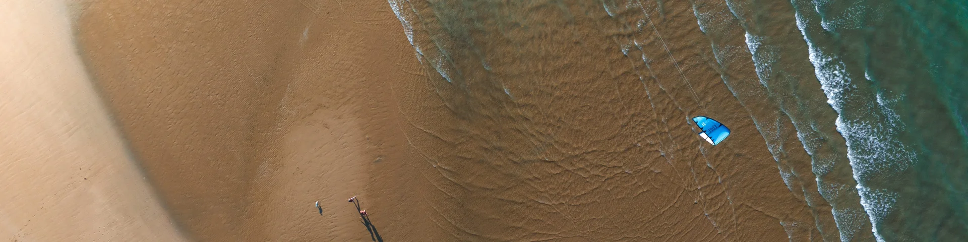 Vue aérienne d'une plage avec un kite surfer.