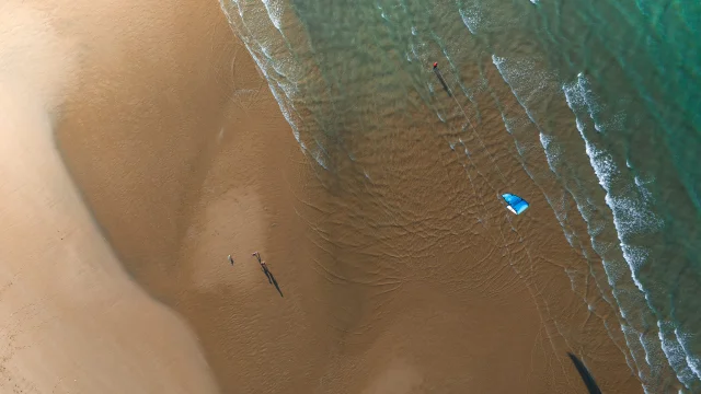 Vue aérienne d'une plage avec un kite surfer.