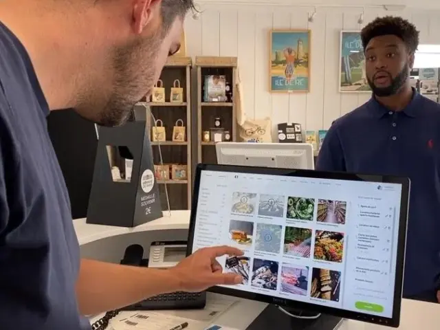 Un conseiller en séjour utilise l'interface tactile du Roadbook pour accompagner un visiteur.
