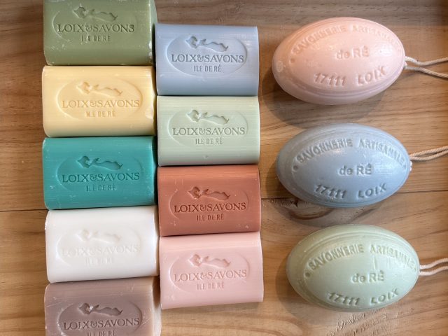 Ensemble de savons artisanaux colorés de la marque Loix & Savons, fabriqués sur l’île de Ré, présentés sur une table en bois.