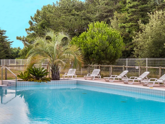 Bassin extérieur d’AquaRé entouré de transats et de verdure