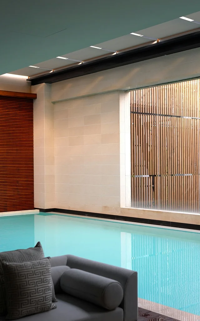 Piscine intérieure avec grandes baies vitrées et espace détente dans un spa contemporain