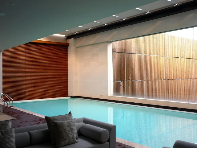 Piscine intérieure avec grandes baies vitrées et espace détente dans un spa contemporain