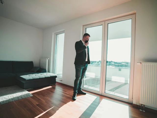 Un agent immobilier présente un appartement lumineux avec vue sur la mer à un client.