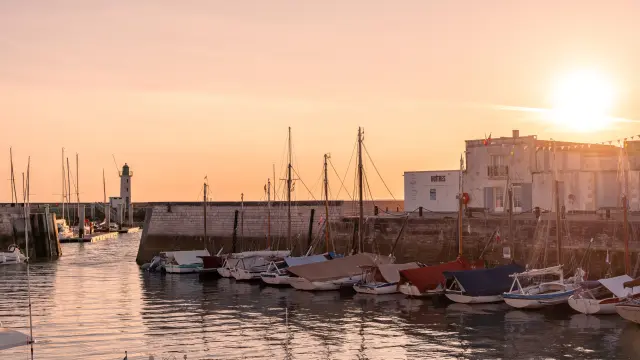 Des voiliers sont amarrés dans le port de La Flotte au coucher du soleil.