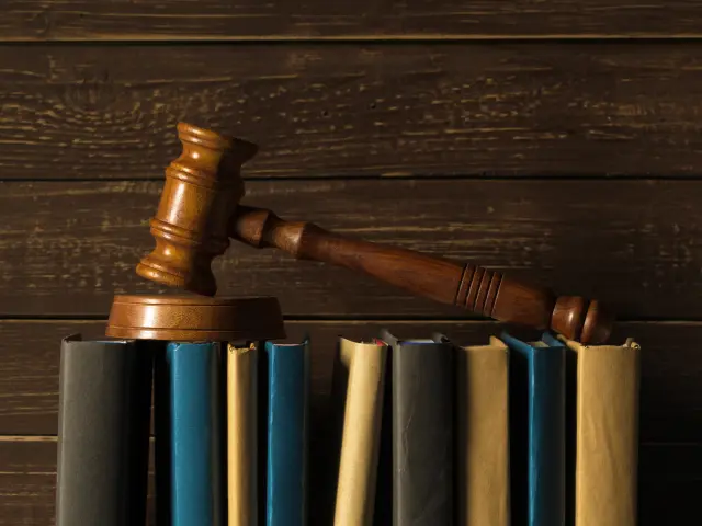 Gavel With Books On Old Wooden Desk
