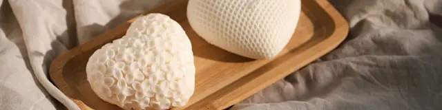 Two white, heart-shaped objects are placed on a wooden tray.