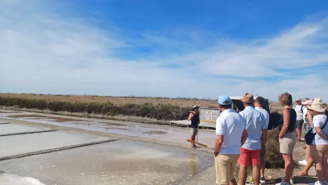 Groupe de visiteurs le long des bassins des marais salants sous un ciel bleu