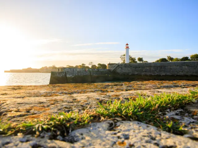 Phare de Saint-Martin éclairé par le soleil levant, vu depuis les fortifications