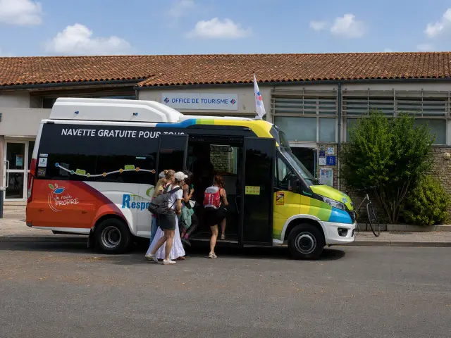 Des voyageurs montent à bord de la navette gratuite de l’Île de Ré à l’arrêt de l’Office de Tourisme du Bois-Plage-en-Ré.